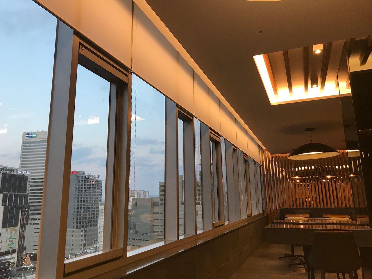 Long corridor with views of the city skyline enhancing the ambiance at Dongdaemun Novotel Ambassador Hotel.